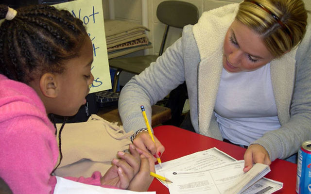 A tutor helps a student do homework in the NJ After 3 program run by JFS in Linden, now facing questions about funding. Photo courtesy JFS