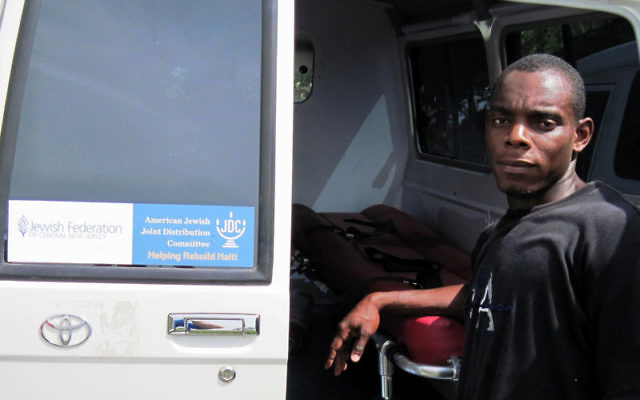 A Haitian worker checks out the ambulance purchased with funds raised by the Jewish Federation of Central New Jersey and delivered last month. Photo courtesy American Jewish Joint Distribution Committee