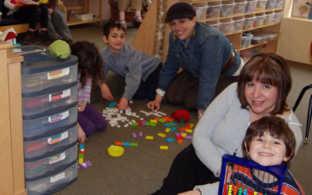 Malkie Herson, center, educational director of the Chabad Jewish Center in Basking Ridge, and teacher Melissa Yarger play word games with kindergarten students. Photo by Elaine Durbach