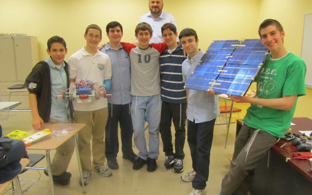 The JEC students chosen to take place in the final round of the international Gildor invention competition in Israel are, from left, Micah Lebowitz, Ethan Lerner, Noam Shachak, Pinchas Teitz, Tzvi Vogel, Rafi Taub, and Shimon Niren. Behind them is their c