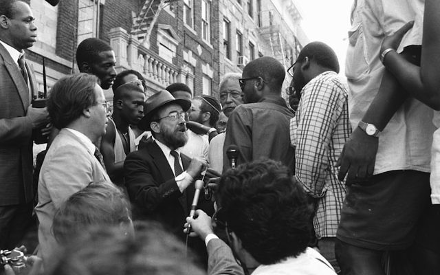 New York City Mayor David Dinkins, fourth from right, looking on while a Hasidic Jew and a black man argue during riots in Crown Heights, Brooklyn, in 1991.