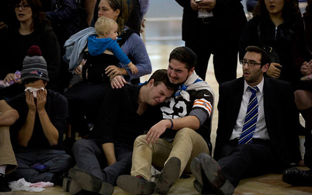 Friends of Ezra Schwartz grieving for the American terror victim at a service at Ben Gurion Airport in Israel before the body was repatriated to Boston for his funeral the following day, Nov. 21, 2015. (AP Images/Oded Balilty)