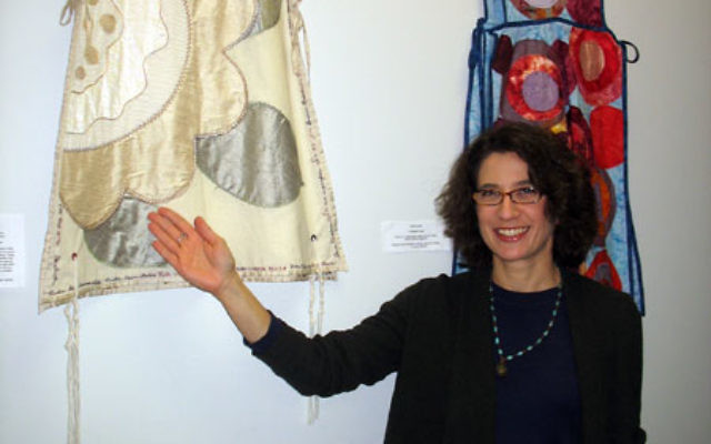Rachel Kanter with two of her tallitot on display at Congregation Shomrei Emunah in Montclair. Photo by Johanna Ginsberg