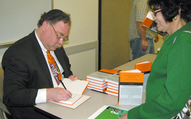 Rabbi Alan Brill signs a copy of his new book, Judaism and Other Religions: Models of Understanding, at Seton Hall University March 21. Photo by Robert Wiener