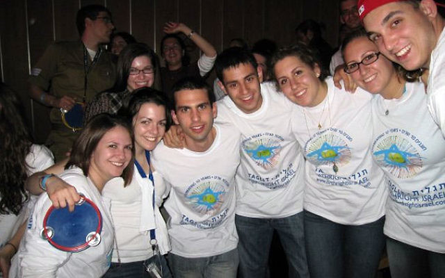 In Jerusalem, Carly Rosenberg, left, at the Mega Event celebrating Taglit-Birthright Israel’s 10-year anniversary, with members of her group; with them is, third from the left, Nadav Schachter, an Israeli soldier who joined them for the trip.