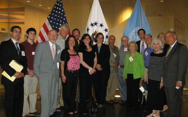 MetroWest Community Relations Committee delegates met with United States Foreign Service officer Barbara Masilko, center, in front of white flag, at the U.S. Mission to the United Nations. Photo by Robert Wiener