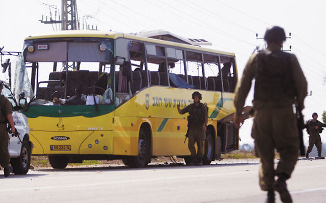 Israeli soldiers outside a school bus that was hit by a rocket near Sderot from the Gaza Strip, injuring two, including a teenager seriously, April 7. Photo by Dima Vazinovich/Flash90/JTA