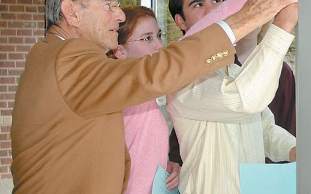 Eric F. Ross helps affix a mezuza to the entrance to Solomon Schechter Day School of Essex and Union’s upper school in West Orange in 2008 at the school’s rededication following a renovation. Photo courtesy SSDSEU