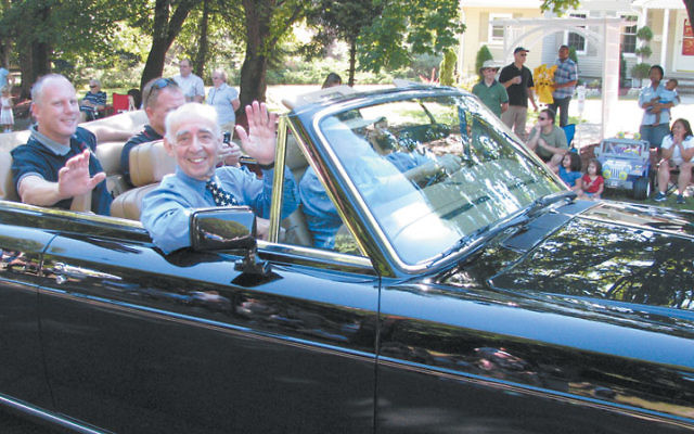 Waving to the crowd from the front seat of a Rolls Royce convertible, Jack Schrier greets constituents during the 2008 Labor Day parade in his hometown of Mendham. Photo by Robert Wiener