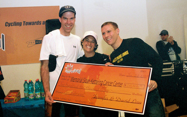 Jennifer and Dave Linn, right, present Dr. Robert Maki of Memorial Sloan-Kettering Cancer Center with a check following the inaugural Spin4Survival in January 2007.