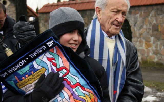 A day before his bar mitzva Zachary Karger carries a Torah scroll that his grandfather, Ed Mosberg, right, retrieved after it had been seized by the Nazis during World War II.