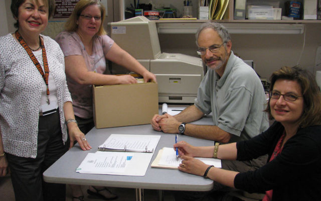 Jewish Historical Society of MetroWest executive director Linda Forgosh, left, and archivist Jill Hershorin present the supermarket archives to Ronald Becker and Fernanda Perrone of Rutgers University’s Alexander Library. Photos by Robert Wiener