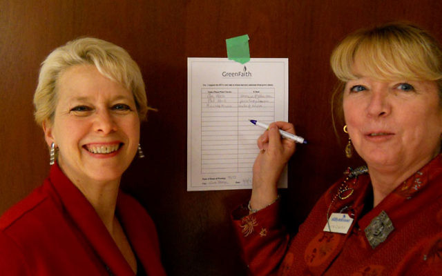 Temple Sharey Tefilo-Israel board member Lynne Crawford, right, and Green Team cochair Sue Hoch with their synagogue’s petition to support EPA rules to reduce mercury emissions.