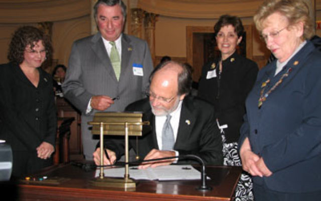 Gov. Jon Corzine signs a proclamation in May 2008 designating May as New Jersey-Israel Sister State Month. Looking on are, from left, Andrea Yonah, Leonard Posnock, and Marlene Herman of the New Jersey-Israel Commission; and state Sen. Loretta Weinberg.