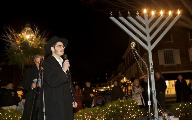 Rabbi Levi Dubov addresses the crowd at the Chabad of Mercer County Hanukka celebration in Princeton last year.