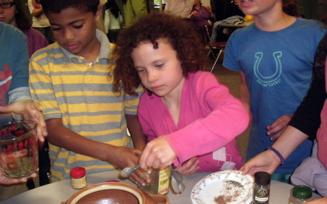 Students at String of Pearls’ religious school prepare grape leaves for their snack.