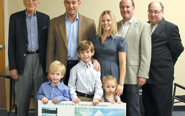 The Wilson family meet with Jewish Community Campus officials, from left, cochair Ron Berman, Matt and Staci Wilson, cochair Ron Berman, and executive director Drew Staffenberg, and, holding a board displaying pictures of the new campus, from left, Noah