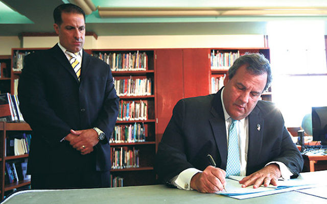 Gov. Chris Christie signs the Secure Schools for All Children Act into law.     