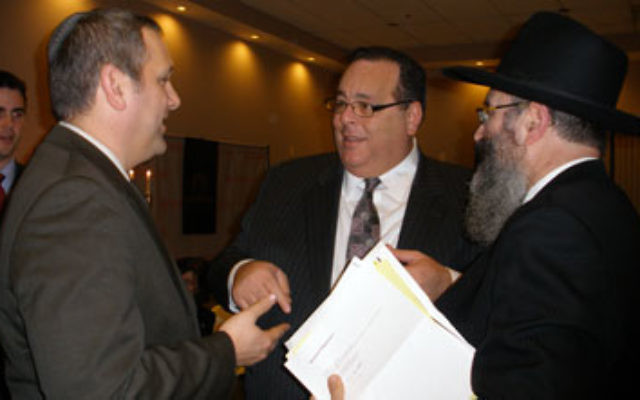Rutgers Chabad executive director Rabbi Yosef Carlebach, right, greets deputy Israeli consul general Benjamin Krasna, left, and others at Chabad’s Hanukka dinner on Dec. 17.