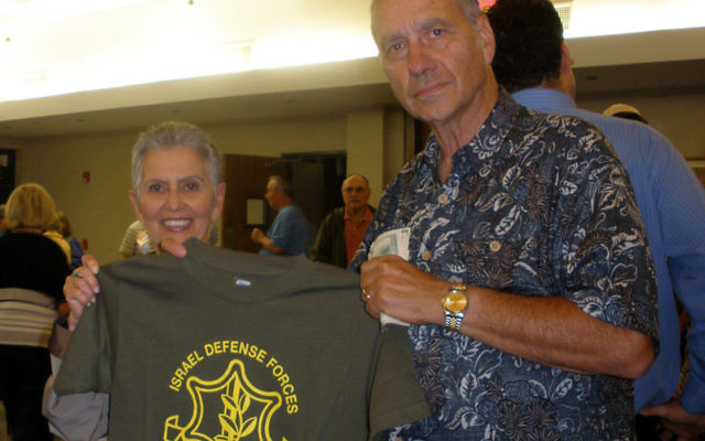 Ann and Paul Lerner of Somerset hold an IDF T-shirt sold at a Temple Beth El program to pay for such niceties as Shabbat meals for Israeli soldiers. Photos by Debra Rubin