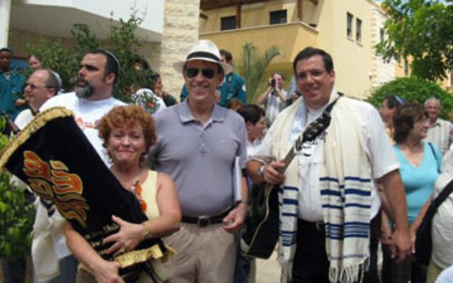 Estelle Marcus holds a Torah scroll donated by Congregation Neve Shalom to Sukkat Shalom, a Masorti synagogue. With her is Neve Shalom’s Rabbi Gerald Zelizer, and, right, a Sukkat Shalom member.