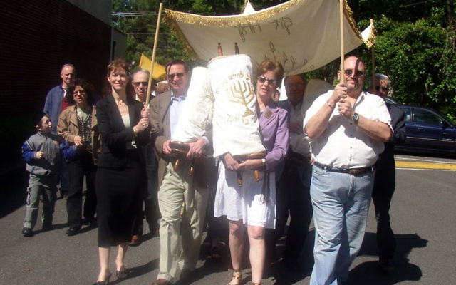 Neve Shalom congregants parade with members of Congregation Adath Israel in Woodbridge as they carry Torah scrolls from the Woodbridge synagogue before placing them in their new home in Metuchen, as the two synagogues merged on May 21, 2006. Photo by De