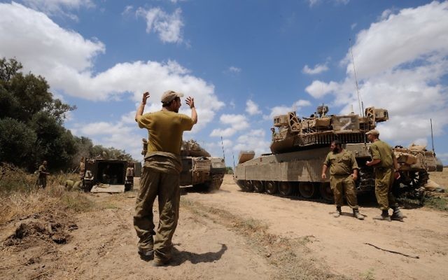 An Israeli soldier directing a Merkava tank, at an army deployment area near Israel’s border with the Gaza Strip, on July 17, 2014. (Gili Yaari/Flash90)