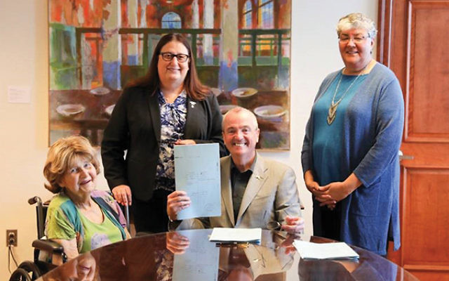 Babs Siperstein, left, watches as Gov. Phil Murphy signs the law simplifying the procedure to change gender identity on birth certificates. Looking on are Jennifer Long, standing, left, and Sue Fulton. (Photo courtesy of Office of Gov. Phil Murphy)