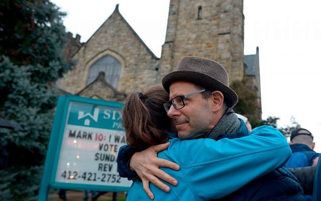Matthew Chinman, 49, of Squirrel Hill, hugs a fellow community member during a vigil held to remember those who died earlier in the day during a shooting at the Tree of Life Synagogue in the Squirrel Hill neighborhood of Pittsburgh on October 27, 2018. - The gunman who killed 11 people at a synagogue in Pittsburgh will face federal charges that carry the death penalty, the US Justice Department said. (Photo by Dustin Franz / AFP)        (Photo credit should read DUSTIN FRANZ/AFP/Getty Images)