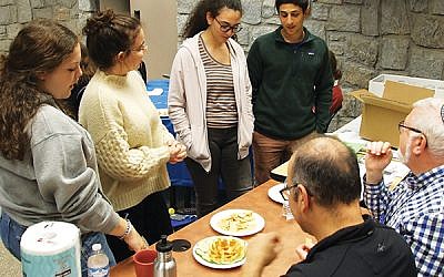During the simulated “Chopped” competition, New Jersey students Maya Mehlman of Springfield, second from left, and Adi David of Livingston, far right, and other teammates present their hummus creation to the judges.