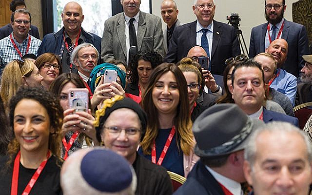 Man of the people: Israeli President Reuven Rivlin (back row, second from right) chose to go to the back of the crowded room to pose with the participants of the Jewish Media Summit at his residence Nov. 28. Courtesy Government Press Office