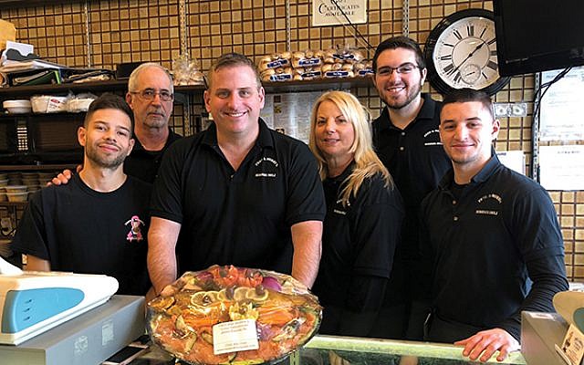 Owner Dan Richelson, with platter, with some of his employees, from left, Victor Hernandez, Sam Markman, Mindy Michaelson O’Connor, Jake Saslawsky, and Joe Mafia.