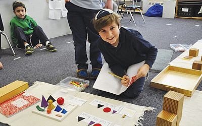 A third grader works with grammar symbols and shapes to learn language construction. Photo courtesy Netivot