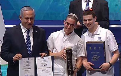 Jacob Colchamiro, at right, placed second in the Chidon HaTanach in Jerusalem. With him, from left, are Prime Minister Benjamin Netanyahu, first-place winner Yonatan Weisman of Israel, and host Dr. Avshalom Kor. Photo from YouTube
