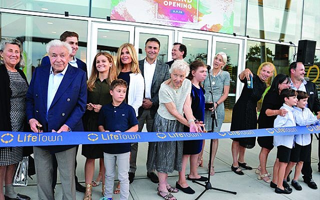 Paula Gottesman, at center, cuts the ribbon at the grand opening of LifeTown: The Jerry Gottesman Center, named for her husband who was an early backer of the project.  Photo by Jerry Siskind
