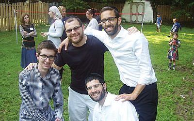 An MJC barbecue in July was attended by, from left, Adam Ilhaber, Steve Tzerlin, and Rabbi Avi Kramer. Kneeling in front is MJC co-director Rabbi Shalom Jacoby. Photos courtesy Manalapan Jewish Connection