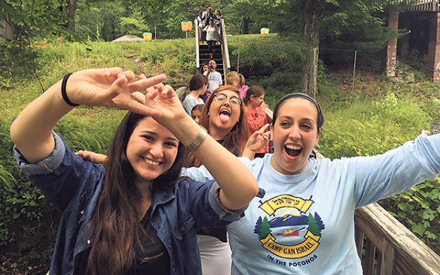 Crossing a bridge at Camp Gan Israel in the Poconos are members of the deaf program — with program director Miriam Kramer, right — Noy Balilty, left, and May Avrahami. 