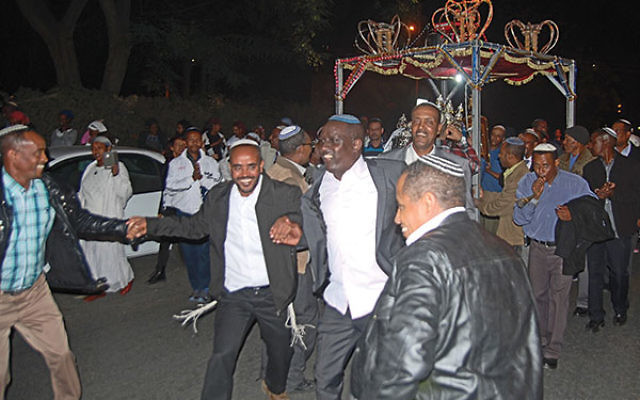 Community members dancing at the dedication of their synagogue&rsquo;s first Torah scroll.