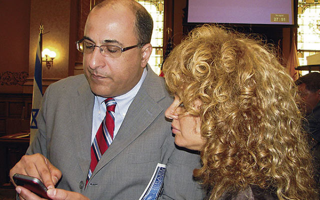 Israeli Consul General Ido Aharoni shows his cellphone apps to Israeli-born violinist Miri Ben-Ari.