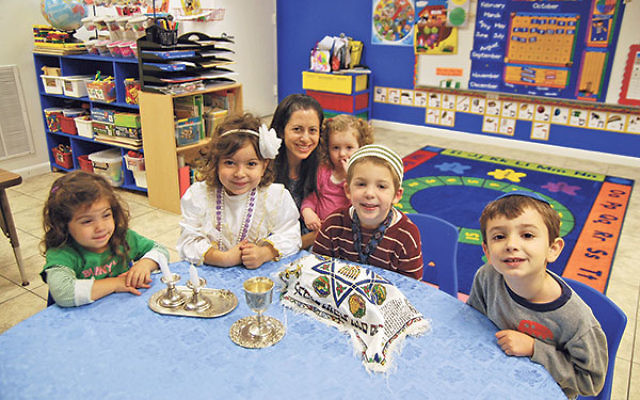 Students join teacher Lori Hirsh in celebrating an early Shabbat at the Yeshiva at the Jersey Shore preschool, then housed at Young Israel of East Brunswick. The Orthodox yeshiva is forming a partnership and moving to the Conservative East Brunswick Jewis
