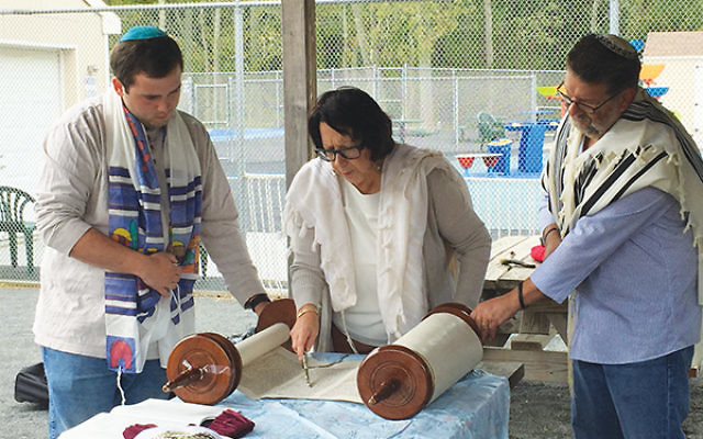 Rabbi Ellie Shemtov of Congregation Kol Am reads Torah with two attendees at the synagogue’s annual second day of Rosh HaShanah service in a Freehold park. The service is free and open to the public. Photo courtesy of Congregation Kol Am
