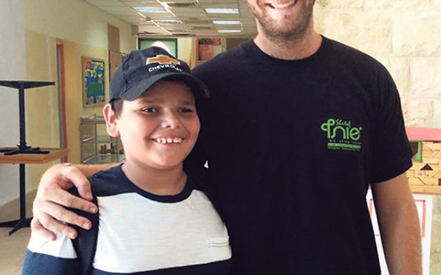 Shalev, a camper from Kiryat Gat, with a Camp Shutaf staff member.