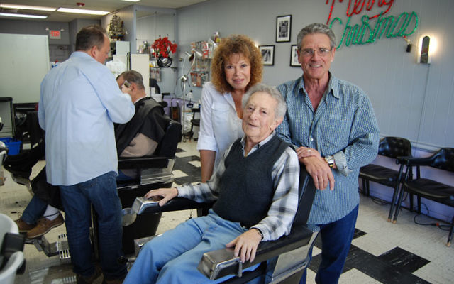 Goldstein takes it easy in his old chair, with current salon owners Carol and Ron Grosso, with whom he worked for 20 years.