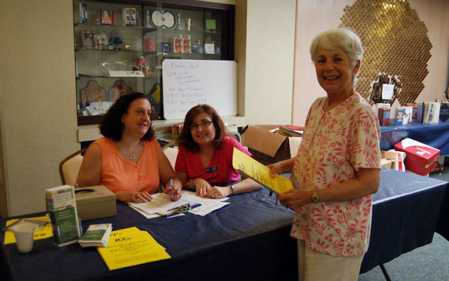 Evelyn Freuler, right, signs in for a JCC adult summer program at Congregation Beth Israel, with volunteers Lori Rosoff, left, and Randy Belfer. Photos by Elaine Durbach