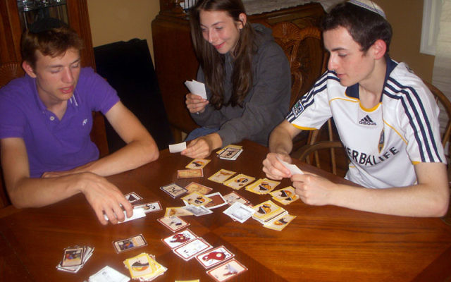 Cholent, The Game! players, from left, Nechemia and Batsheva Kivelevitz, sisters of one of the game’s inventors, and a friend, Hirshel Hall, try their hand at the game.
