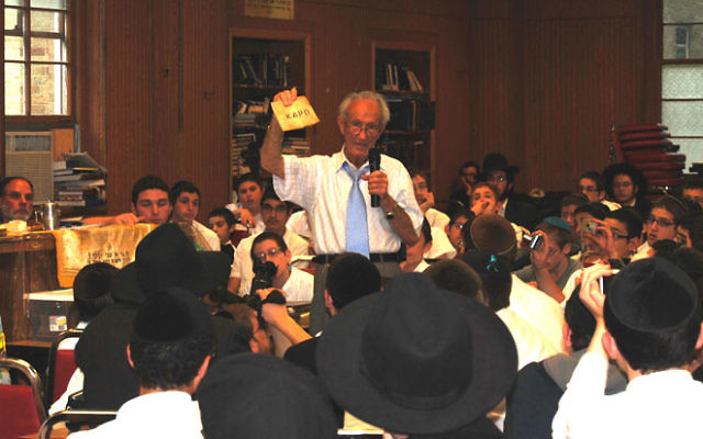 To bring home the reality of the Holocaust to Chabad students in Morristown, survivor Ed Mosberg shows them mementos that he has gathered over the years. Photos by Elaine Durbach