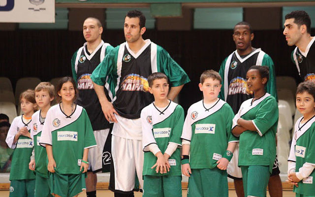 Members of the Maccabi Haifa basketball team share the court with kids from the Maccabi Haifa Youth program. Photo courtesy Maccabi Haifa