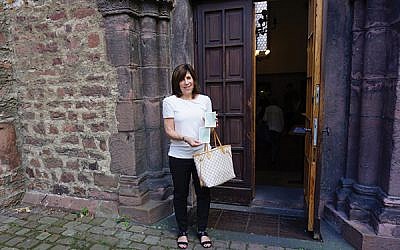 Joan Herz Kamens at the entrance of the Rashi Synagogue in Worms, Germany, holding photos her parents had taken at the same spot. Photos courtesy Kamens family