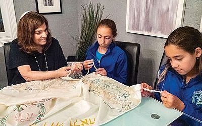 Rabbi Lois Ruderman in a congregant’s home with students looking at tzitzit like the ones they will tie for tallitot of their own.  Photo by Carol Dickert