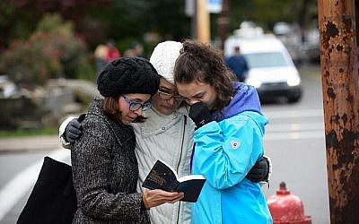 Tammy Hepps, Kate Rothstein and her daughter, Simone Rothstein, 16, pray from a prayerbook a block away from the site of a mass shooting at the Tree of Life Synagogue in the Squirrel Hill neighborhood on October 27, 2018 in Pittsburgh, Pennsylvania. Getty Images